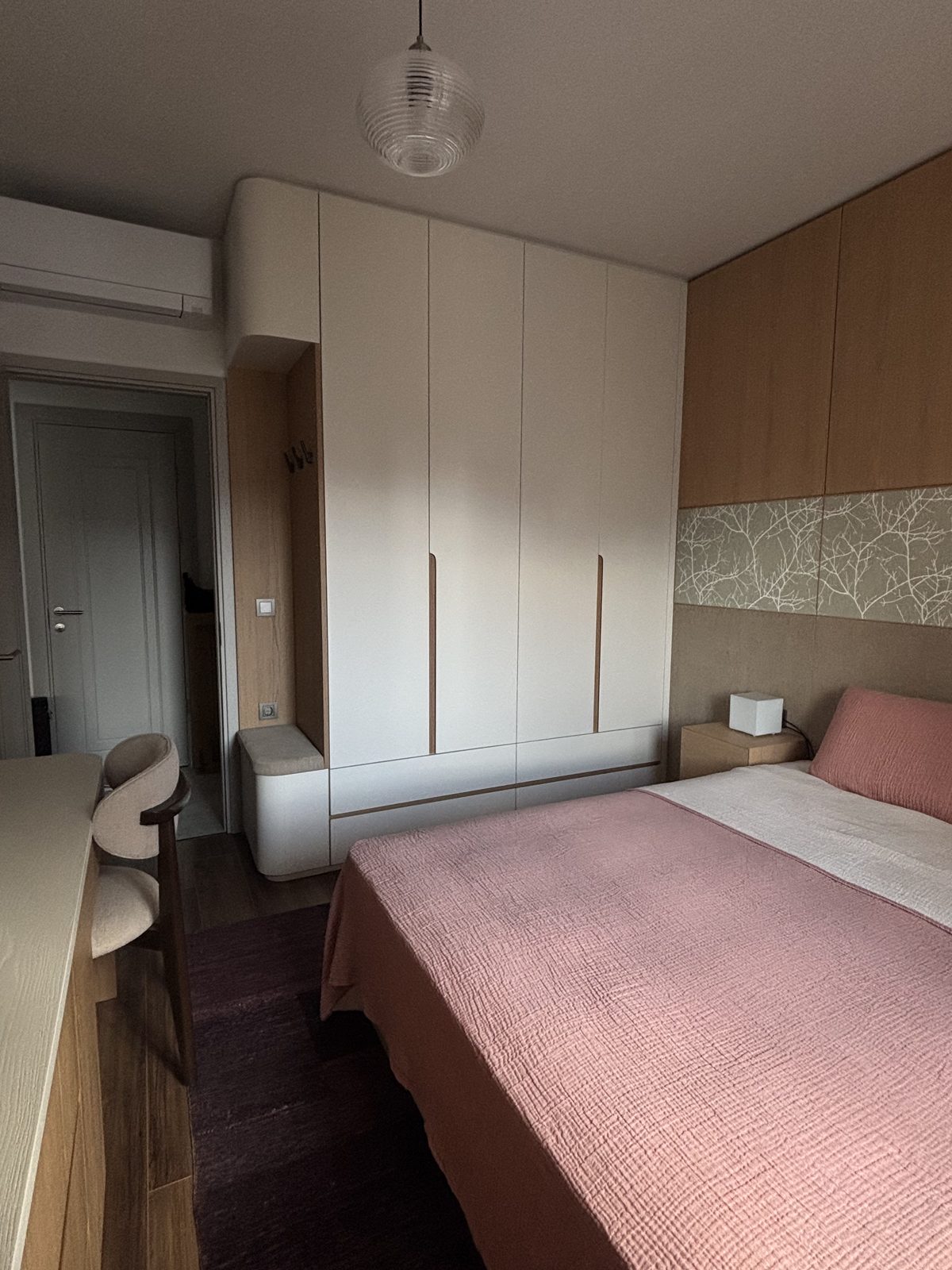 Second bedroom with green headboard and overhead storage